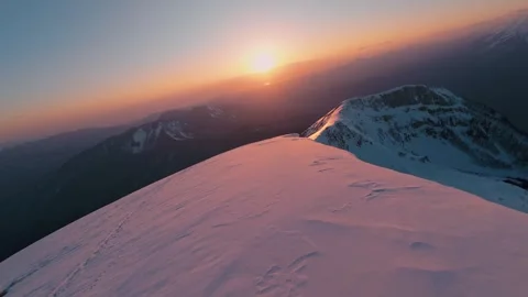 Fast flight over a snow-covered mountain range against the background of the Stock Footage 331206664
