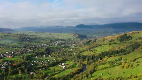 Fast floating clouds over village in mountains. bright houses on green slopes Stock Footage 155299984