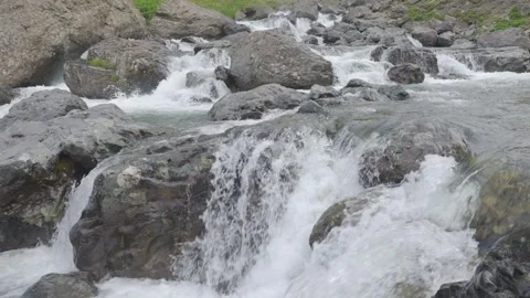 Fast flowing mountain river plunging and crashing over massive stones Stock Footage 341516151