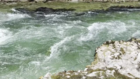 Fast flowing mountain stream rushing between moss-covered rocks Vídeos de archivo 342025039