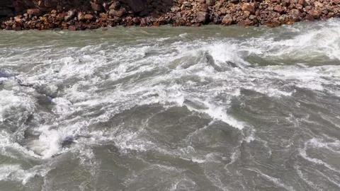 Fast flowing muddy river rapids with turbulent white water churning Vidéo 347764021