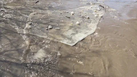 Fast flowing muddy spring river full of pieces of ice flooding as the ice blocks Stock Footage 306552700