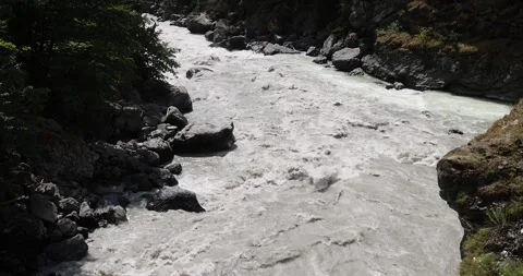 Fast flowing raging river. Soil and mud is moving towards down Stock Footage 260878249