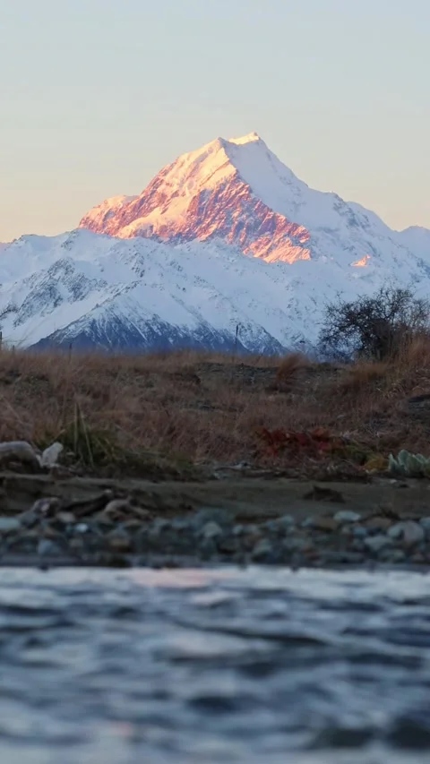 Fast flowing river in front of Mt Cook / Aoraki at sunset Stock-Footage 328134638