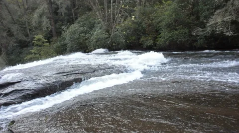 Fast flowing river panned to watefall Stock Footage 58560055