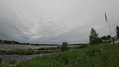 Fast flowing river rapids in Finland with Finnish flag fluttering in the breeze Stock Footage 340332929