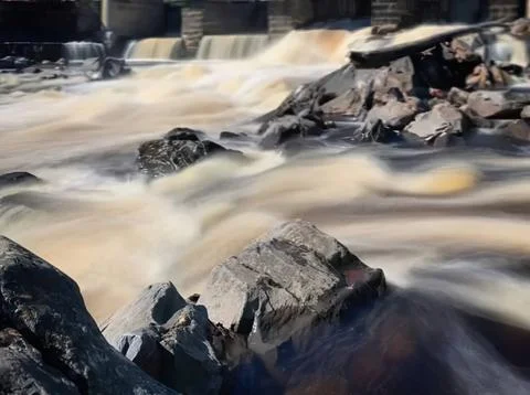 Fast flowing river with rocks and water in motion outdoors Foto stock