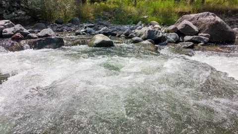 Fast-flowing river stream over rocky terrain Stock Photos