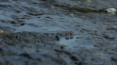 Fast flowing river in summer, close up on water surface as camera pans up Stock Footage 113600607