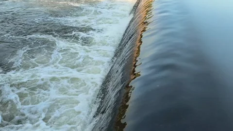Fast-Flowing River Water Cascading Over a Small Weir Stock Footage 341536385