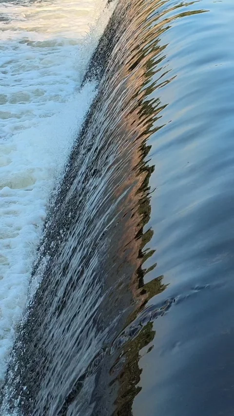 Fast-Flowing River Water Cascading Over a Small Weir Stock Footage 341536392