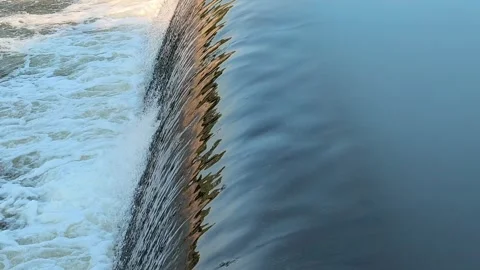 Fast-Flowing River Water Cascading Over a Small Weir Stock Footage 341536405