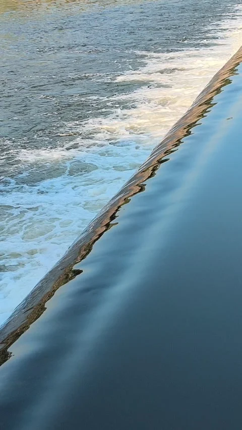 Fast-Flowing River Water Cascading Over a Small Weir Stock Footage 341536416