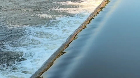 Fast-Flowing River Water Cascading Over a Small Weir Stock Footage 341536420