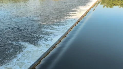 Fast-Flowing River Water Cascading Over a Small Weir Stock Footage 341536423