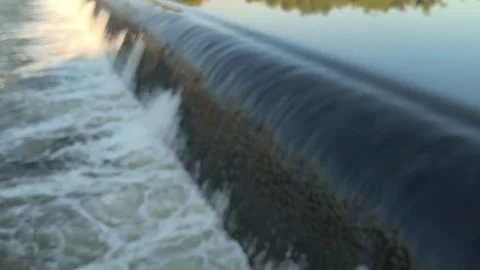 Fast-Flowing River Water Cascading Over a Small Weir Stock Footage 341536436