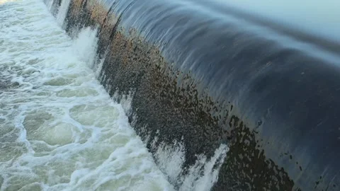 Fast-Flowing River Water Cascading Over a Small Weir Stock Footage 341536564