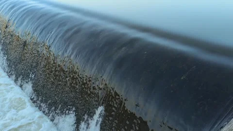 Fast-Flowing River Water Cascading Over a Small Weir Stock Footage 341536594