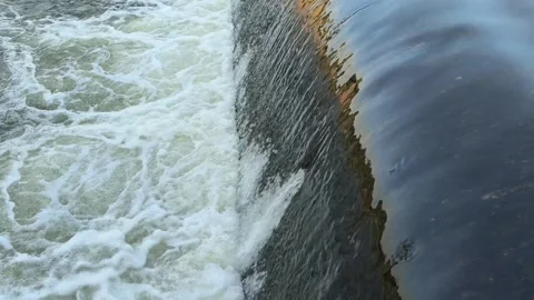 Fast-Flowing River Water Cascading Over a Small Weir Stock Footage 341536610
