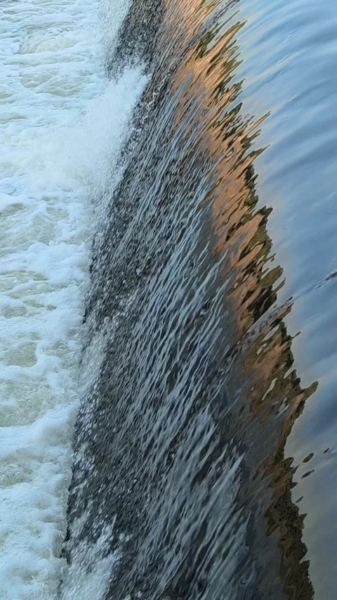 Fast-Flowing River Water Cascading Over a Small Weir Stock Footage 341536645