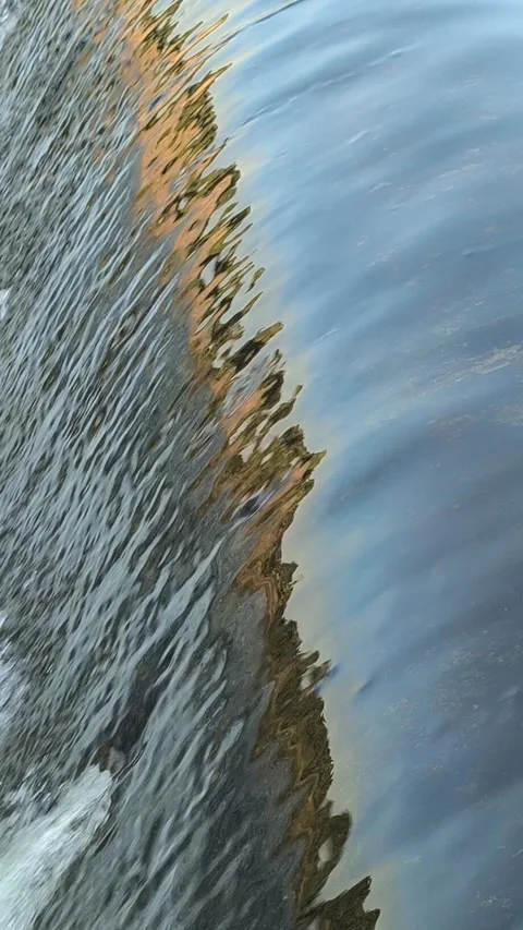 Fast-Flowing River Water Cascading Over a Small Weir Stock Footage 341536646