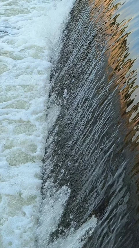 Fast-Flowing River Water Cascading Over a Small Weir Stock Footage 341536647