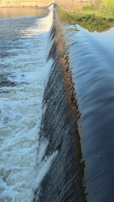 Fast-Flowing River Water Cascading Over a Small Weir Stock Footage 341536660