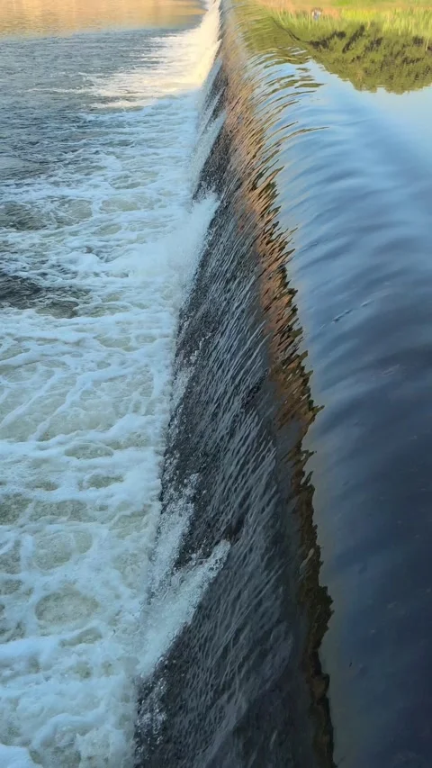 Fast-Flowing River Water Cascading Over a Small Weir Stock Footage 341536662