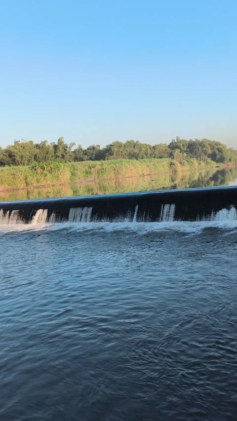 Fast-Flowing River Water Cascading Over a Small Weir Stock Footage 341536663