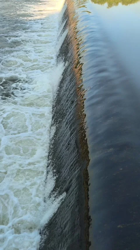 Fast-Flowing River Water Cascading Over a Small Weir Stock Footage 341536668