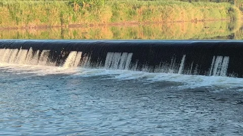 Fast-Flowing River Water Cascading Over a Small Weir Stock Footage 341536677