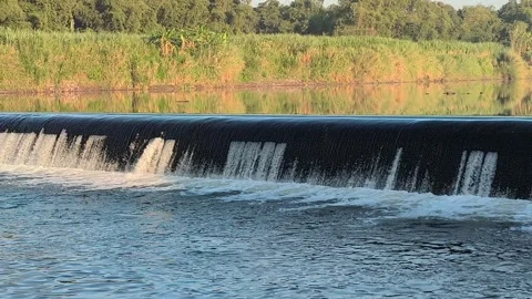 Fast-Flowing River Water Cascading Over a Small Weir Stock Footage 341536678