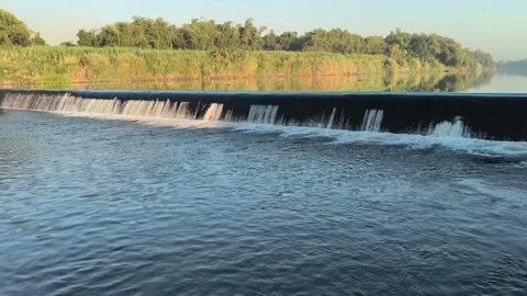 Fast-Flowing River Water Cascading Over a Small Weir Stock Footage 341536679
