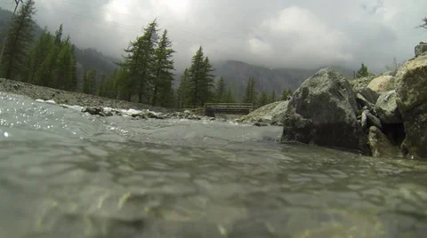 Fast Flowing Stream Surrounded by Mountainous Environment 1 Stock Footage 27462616