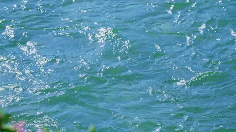 Fast flowing turquoise river water surface with sun glints 스톡 동영상 345255410