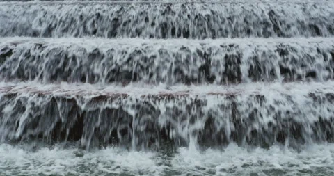 Fast flowing water cascading down steps or ledges in a weir Video stock 152754188