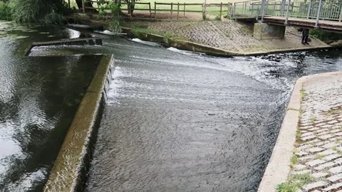 Fast flowing water running over a weir on River Stour near Sudbury Stock Footage
