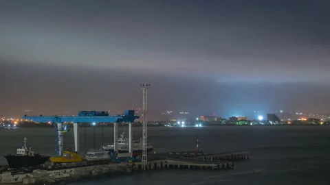 Fast flying clouds in the night starry sky over the port Stock Footage 142187357