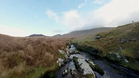 Fast Flying Fpv Drone View Rocky River Flow In Ireland surrounded by mountain Video stock 262974429