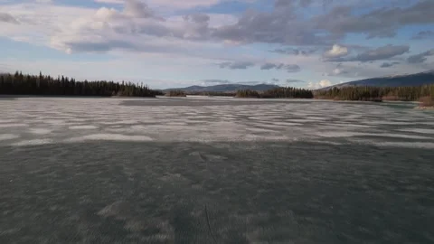 Fast flying over an ice covered lake then ascending Stock Footage 308668269