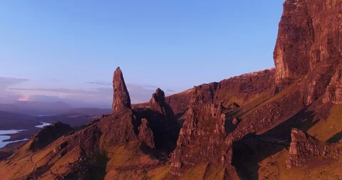 Fast flying panoramic sunrise view of Old Man Storr, Scotland drone aerial 4K Stock Footage 104580819