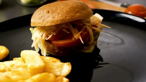 Fast food, Beef burger rotating 360 loop on the black plate on black background Stock Footage 336579133