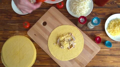 Fast food cooking. Hands preparing tortilla, putting tomato on meat Stock Footage 86507657