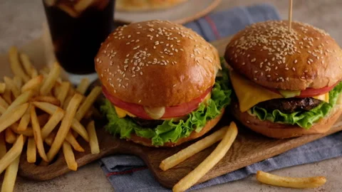 Fast food. Macro, top view of burgers, french fries, cola. A woman made a Stock Footage 130764890
