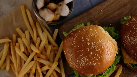 Fast food. Macro, top view of burgers, french fries, cola. A woman made a Stock Footage 130764934