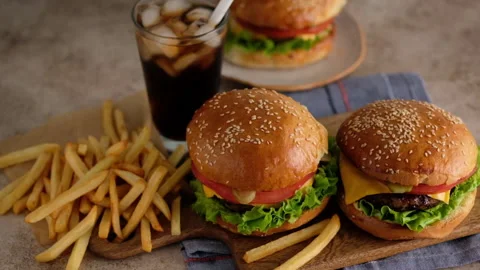Fast food. Macro, top view of burgers, french fries, cola. A woman made a Stock Footage 130764951