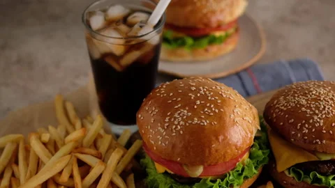 Fast food. Macro, top view of burgers, french fries, cola. A woman made a Stock Footage 137622618