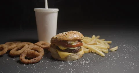 Fast food menu tracking shot in studio. Hamburger with french fries, onion rings Video stock 144799192