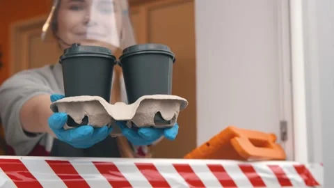 Fast food worker in face shield and gloves in drive thru window serving takeaway Stock Footage 143540125