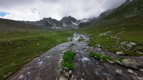Fast forward aerial tracking shot over a rocky alpine river Stock Footage 344967018